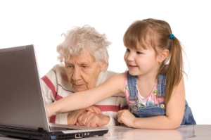 child leading grandparent at computer